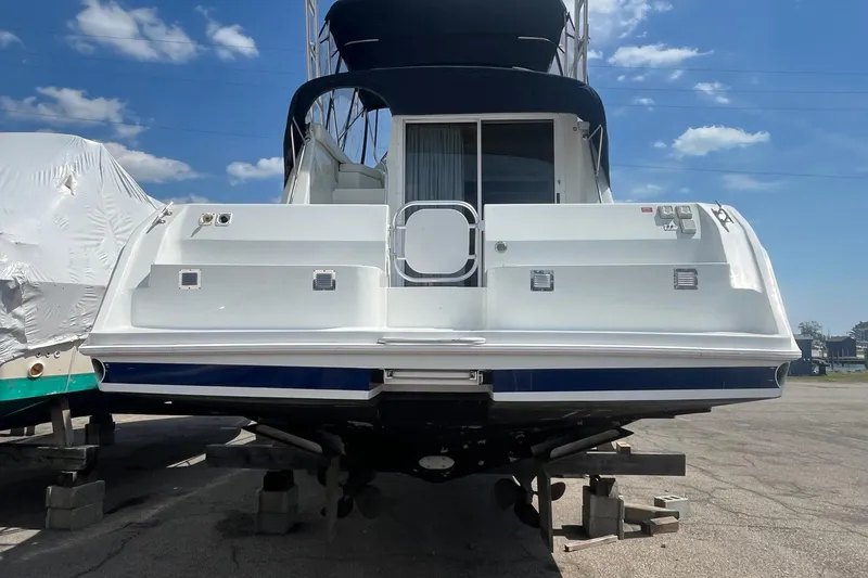 Slide: The Image of 1996 Mainship 40 Sedan Bridge yacht on blocks, rear view under clear sky. - 4