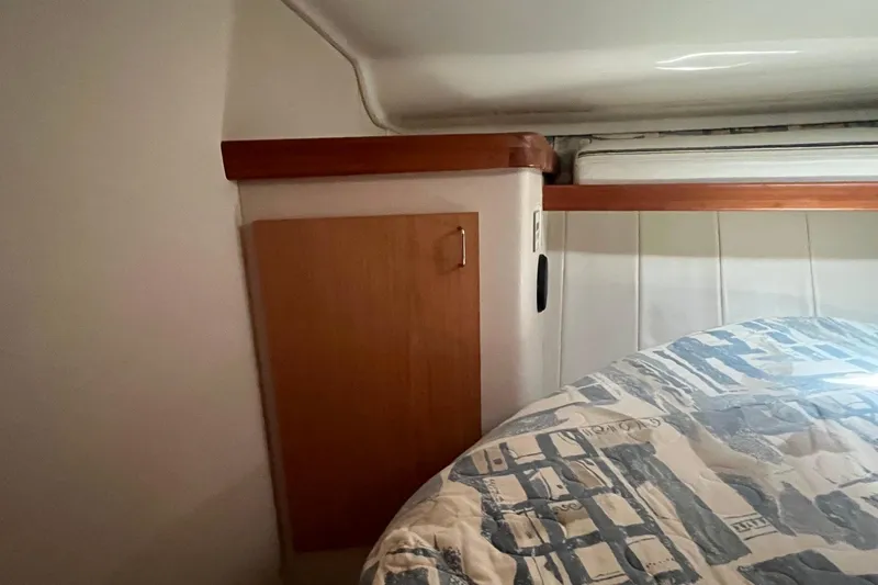 Slide: The Image of Interior cabin of 1996 Mainship 40 Sedan Bridge with wood paneling and bedding. - 41