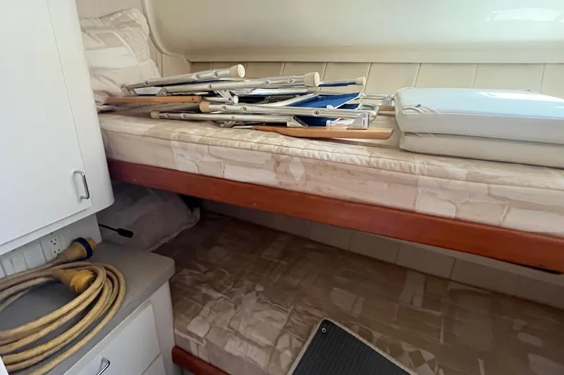 Slide: The Image of Interior of 1996 Mainship 40 Sedan Bridge with bunk beds and stored equipment. - 42
