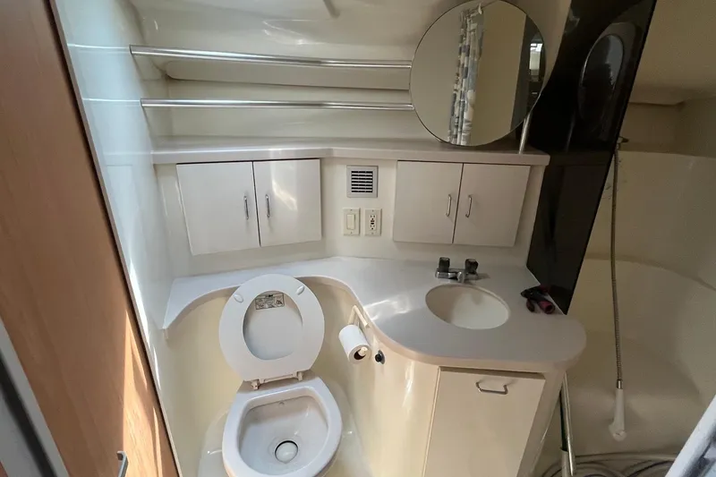 Slide: The Image of Bathroom interior of 1996 Mainship 40 Sedan Bridge yacht, featuring sink, toilet, and storage cabinets. - 43