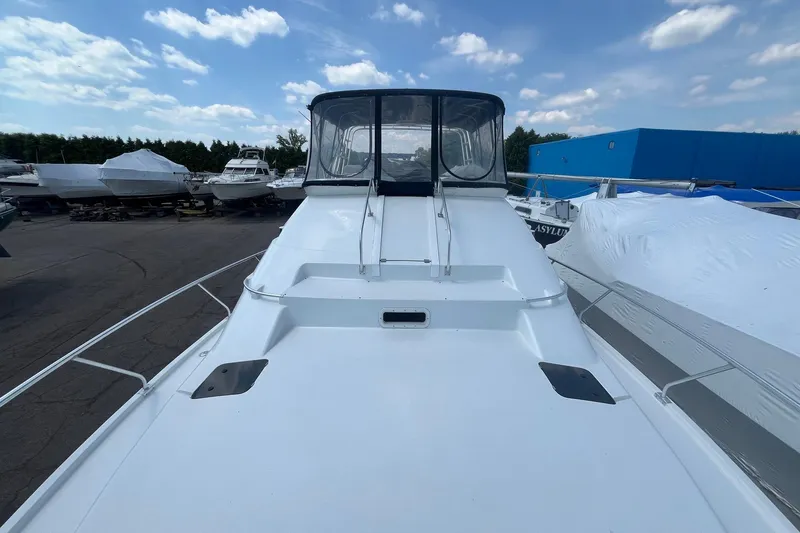 Slide: The Image of 1996 Mainship 40 Sedan Bridge yacht on display at a marina under a blue sky. - 5