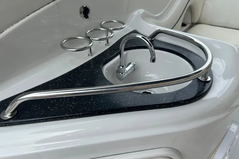 Slide: The Image of 2006 Crownline 270 CR boat sink with chrome fixtures and cup holders. - 14