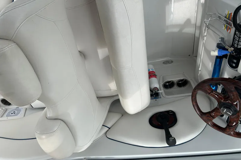 Slide: The Image of Interior of a 2006 Crownline 270 CR boat with white seating and wooden steering wheel. - 20