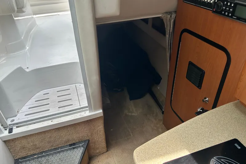 Slide: The Image of Interior view of a 2006 Crownline 270 CR boat cabin with carpeted flooring. - 30