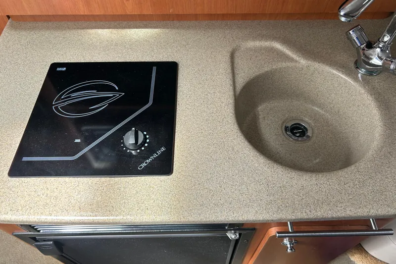 Slide: The Image of 2006 Crownline 270 CR boat kitchenette with stove and sink. - 33