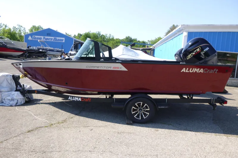 Slide: The Image of 2024 Alumacraft Competitor 185X Sport boat on trailer at marina. - 1
