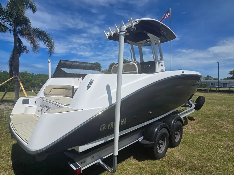 Slide: The Image of Yamaha 255 FSH Sport E 2022 on trailer, palm trees in background. - 2