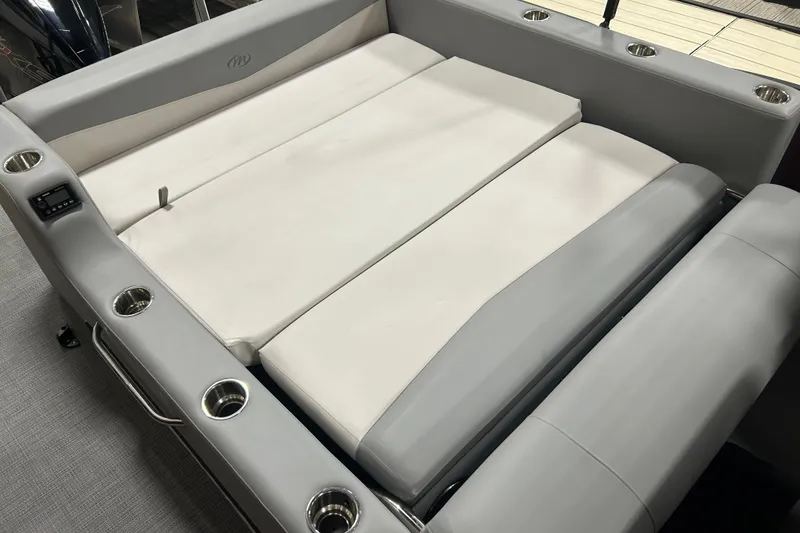 Slide: The Image of 2022 Manitou 25 Encore boat interior with cushioned seating and cup holders. - 19
