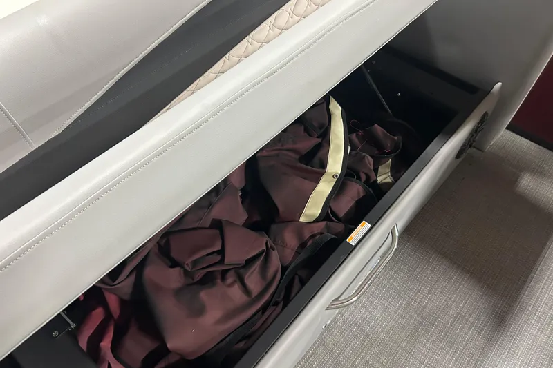 Slide: The Image of Storage compartment in 2022 Manitou 25 Encore boat, containing a folded cover. - 22