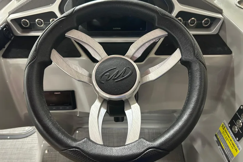 Slide: The Image of Steering wheel of 2022 Manitou 25 Encore boat, featuring sleek design and controls. - 27