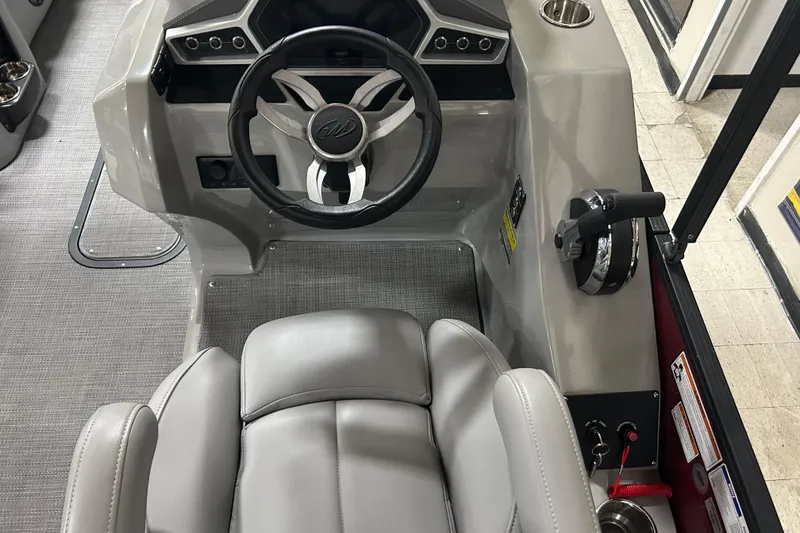 Slide: The Image of 2022 Manitou 25 Encore boat cockpit with steering wheel and controls. - 29
