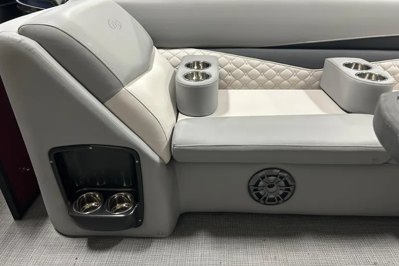 Slide: The Image of 2022 Manitou 25 Encore boat interior with cushioned seating and cup holders. - 33