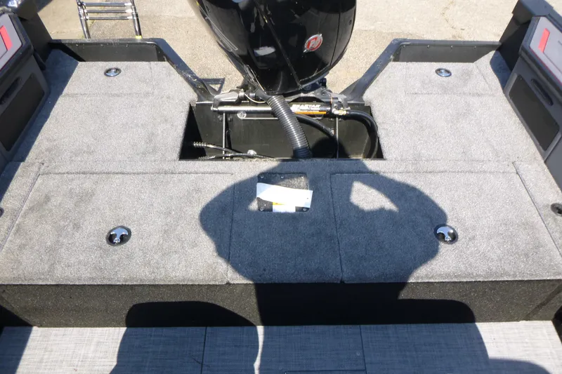 Slide: The Image of 2025 Alumacraft Trophy 185X Sport boat deck with motor and storage compartments. - 15
