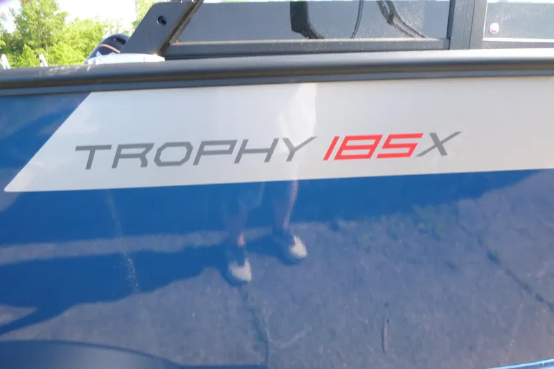 Slide: The Image of 2025 Alumacraft Trophy 185X Sport boat logo on blue exterior. - 19