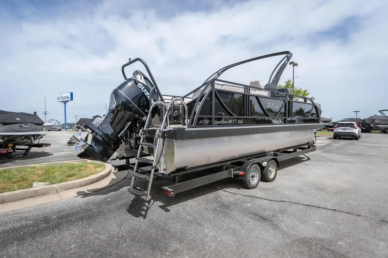 Slide: The Image of 2026 JC Sporttoon 26TT pontoon boat on trailer, featuring Suzuki outboard motor. - 2