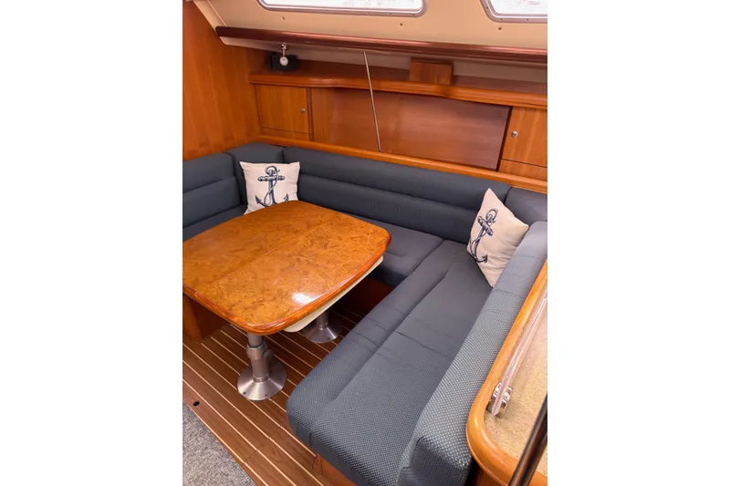 Slide: The Image of Cozy 2007 Hunter 38 sailboat interior with wooden table and cushioned seating. - 17