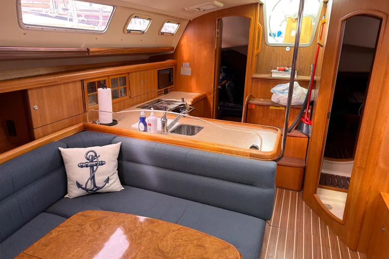 Slide: The Image of Interior of a 2007 Hunter 38 sailboat with cozy seating and wooden cabinetry. - 22
