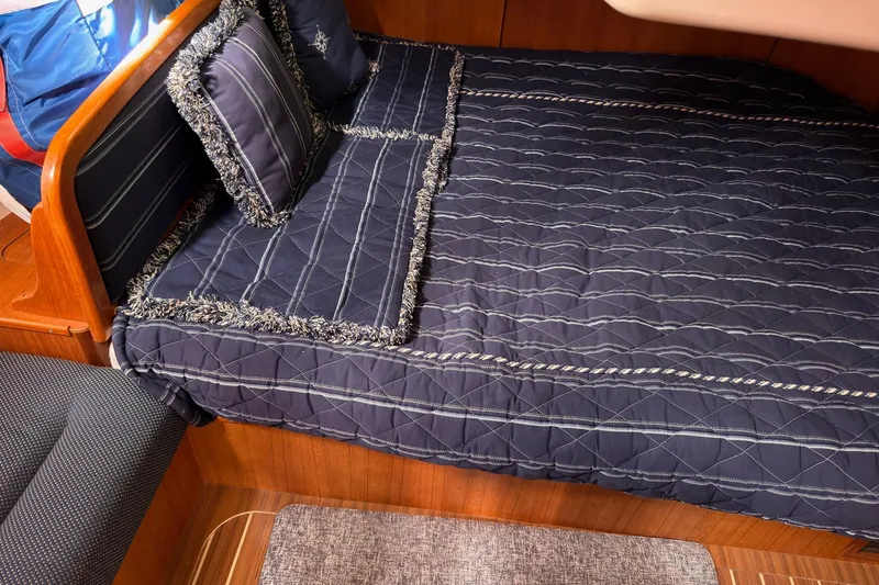 Slide: The Image of Luxurious cabin interior of a 2007 Hunter 38 yacht with navy bedding and wooden accents. - 24