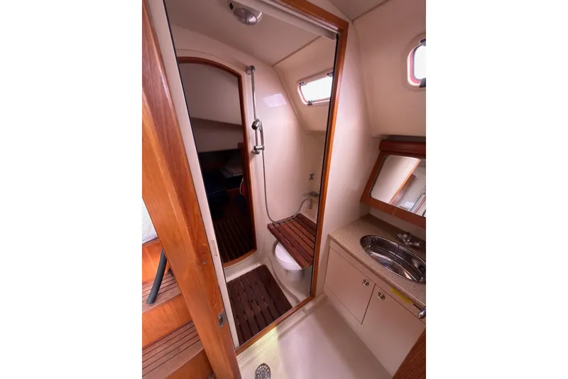 Slide: The Image of Interior of 2007 Hunter 38 sailboat bathroom with shower, sink, and wooden accents. - 27