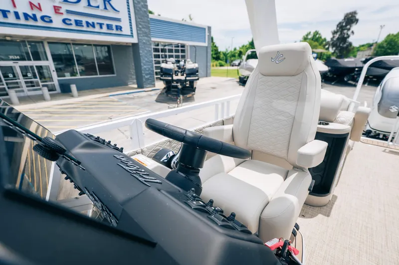 Slide: The Image of 2026 JC Sporttoon 26TT boat interior with luxurious captain's chair at a marine center. - 22