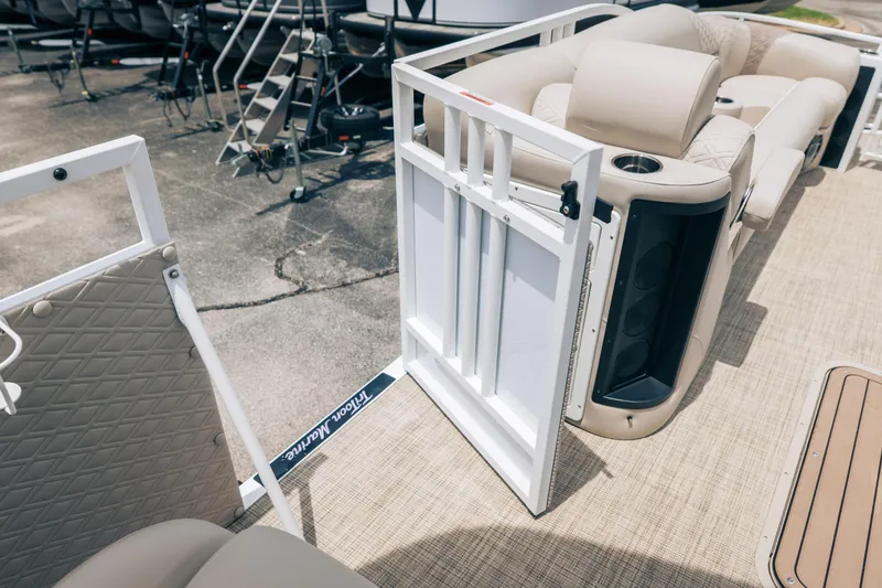Slide: The Image of 2026 JC Sporttoon 26TT pontoon boat interior with open gate and beige seating. - 25