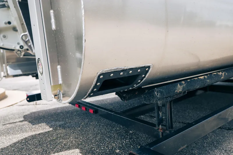 Slide: The Image of Close-up of 2026 JC Sporttoon 26TT pontoon boat on trailer, highlighting aluminum hull detail. - 5
