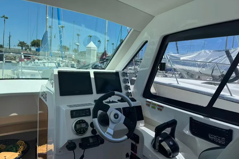 Slide: The Image of Interior view of 2024 Bluewhale 3600 WA boat cockpit with steering wheel and navigation screens. - 16
