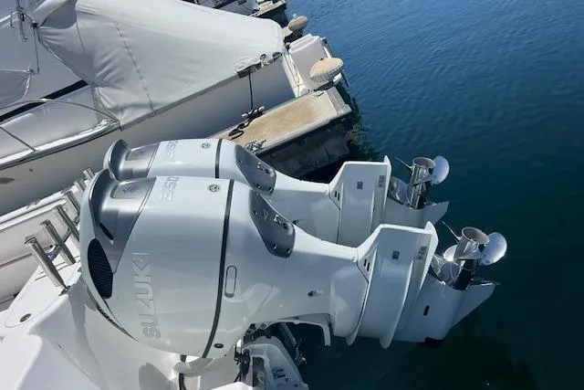 Slide: The Image of Twin Suzuki outboard motors on a 2024 Bluewhale 3600 WA boat docked at a marina. - 8