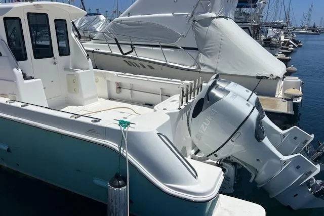 Slide: The Image of 2024 Bluewhale 3600 WA boat docked with dual outboard engines in a marina. - 9