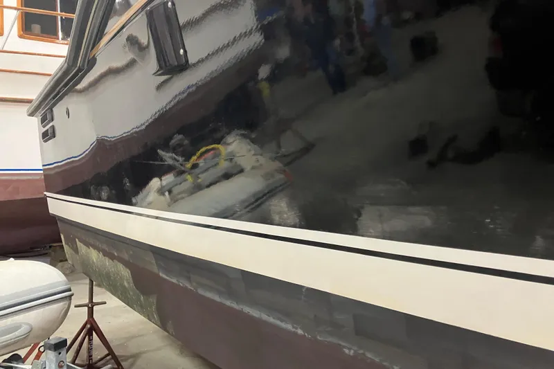 Slide: The Image of 1982 Trojan F-32 boat hull in a workshop, reflecting nearby objects. - 5