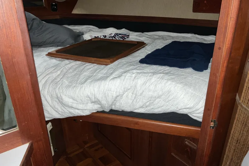 Slide: The Image of Cozy cabin interior of 1982 Trojan F-32 boat with bed and wooden accents. - 14
