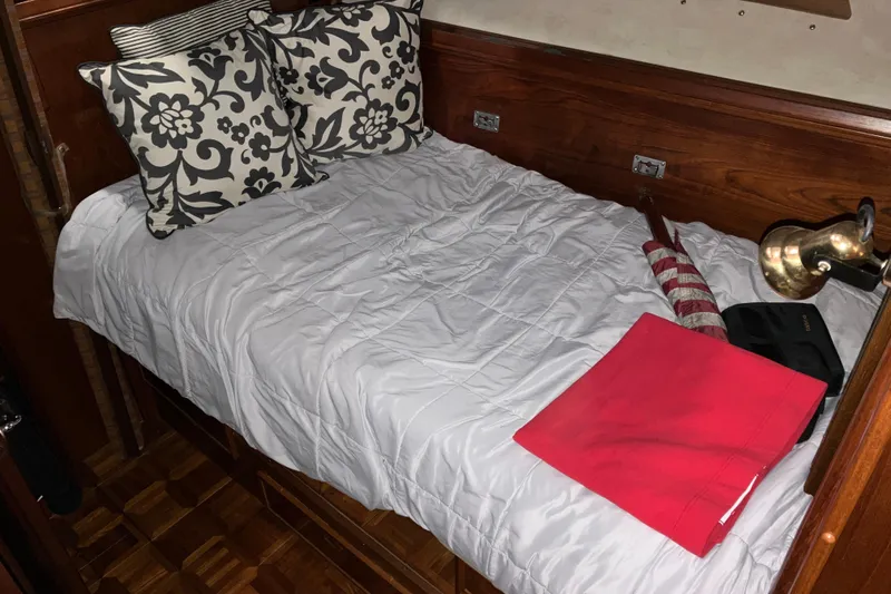 Slide: The Image of Cozy cabin bed in 1982 Trojan F-32 boat with decorative pillows and wooden accents. - 13