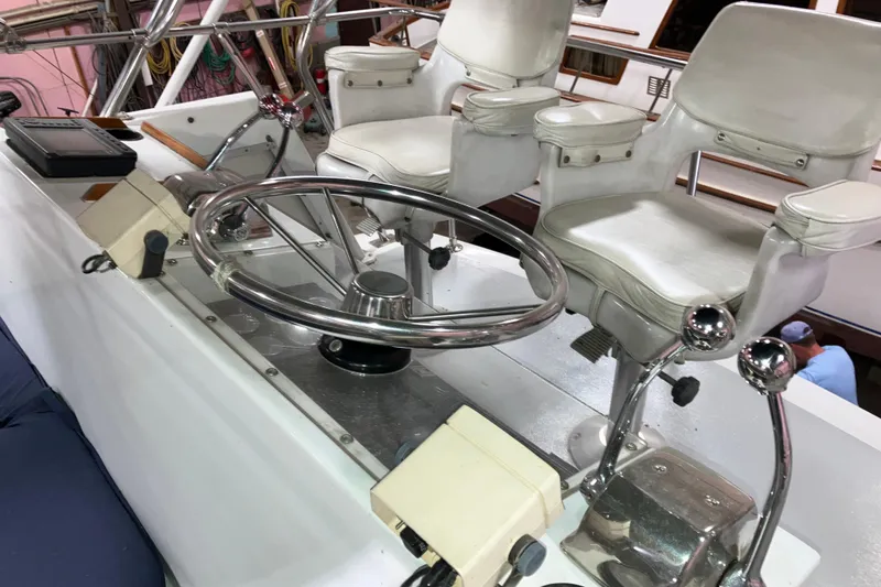 Slide: The Image of 1982 Trojan F-32 boat helm with dual white captain chairs and steering wheel. - 19