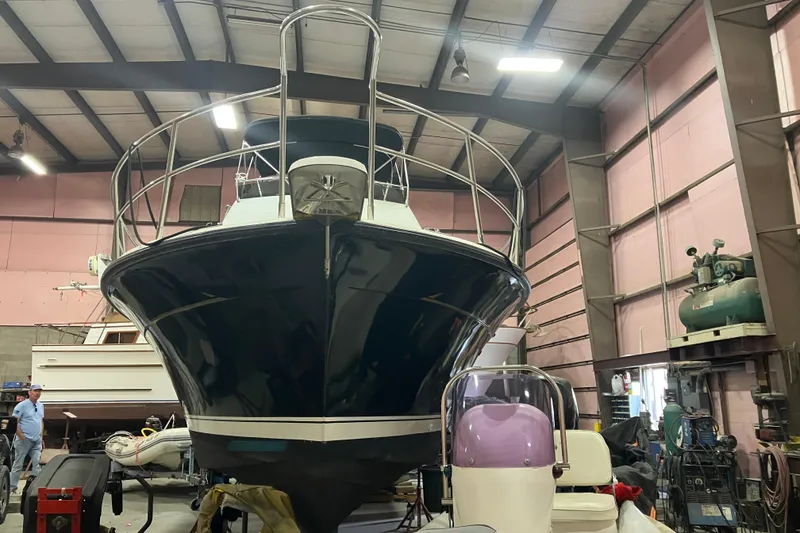 Slide: The Image of 1982 Trojan F-32 boat in a workshop, viewed from the front, under maintenance. - 2