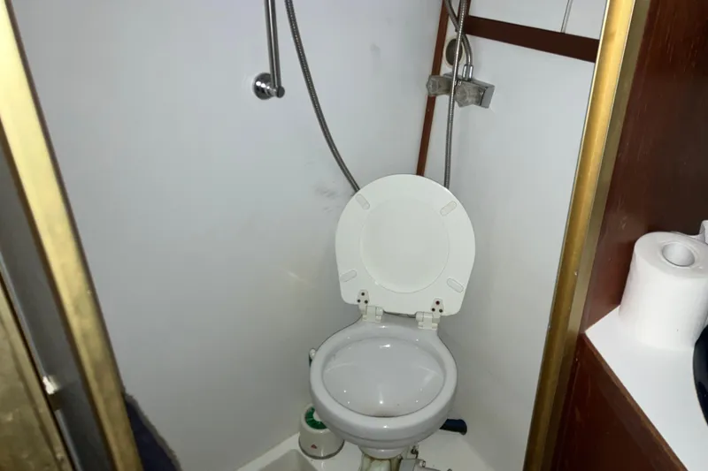 Slide: The Image of 1982 Trojan F-32 boat bathroom with toilet and showerhead. - 17