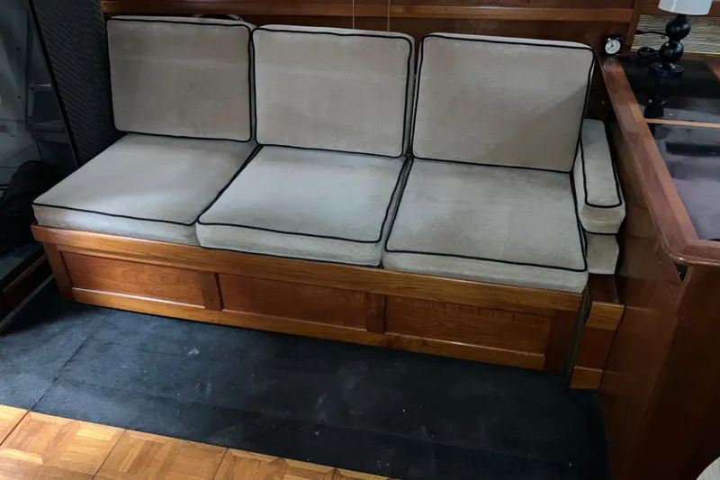 Slide: The Image of 1982 Trojan F-32 boat interior with beige cushioned seating and wooden accents. - 12