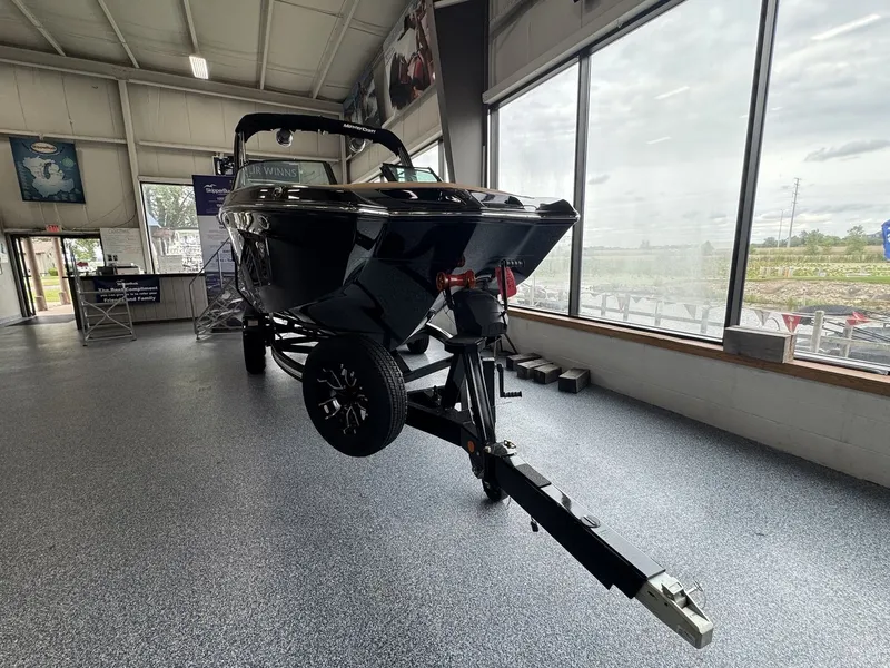 Slide: The Image of A 2026 MasterCraft XT22 is displayed on a trailer in a showroom. - 1