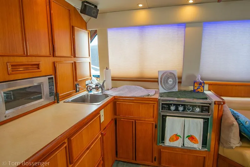 Slide: The Image of Interior of 1988 Chris-Craft 482 Convertible yacht kitchen with wooden cabinetry and appliances. - 10