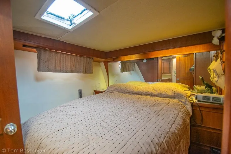 Slide: The Image of Cozy bedroom interior of 1988 Chris-Craft 482 Convertible yacht with wood accents and skylight. - 14
