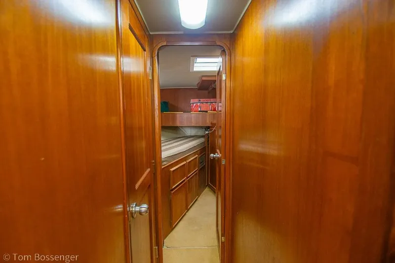 Slide: The Image of 1988 Chris-Craft 482 Convertible interior with wooden paneling and cozy cabin space. - 17
