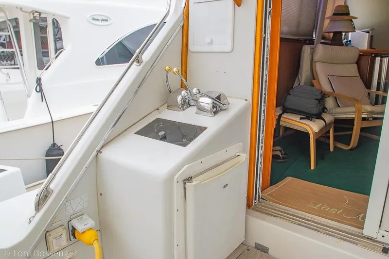 Slide: The Image of 1988 Chris-Craft 482 Convertible yacht interior with seating and kitchenette area. - 25