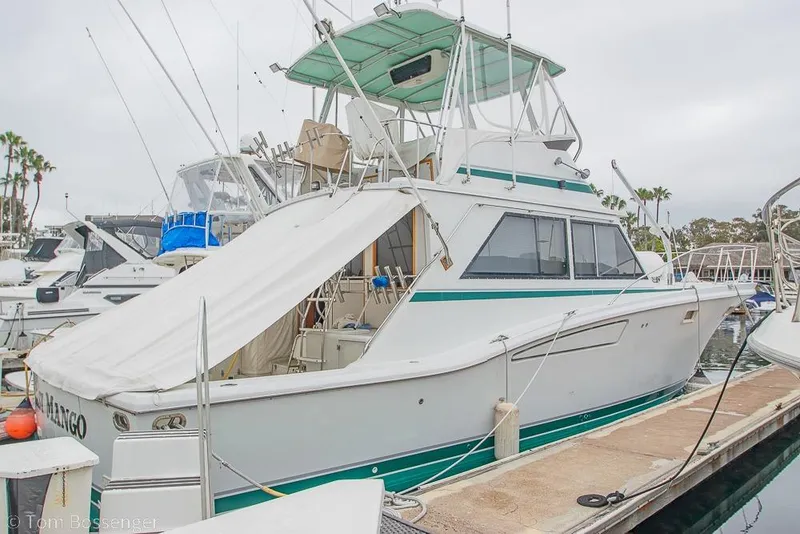 Slide: The Image of 1988 Chris-Craft 482 Convertible yacht docked at marina, featuring classic design and spacious deck. - 3