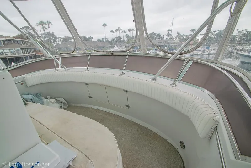 Slide: The Image of Interior view of 1988 Chris-Craft 482 Convertible yacht with curved seating and marina backdrop. - 33