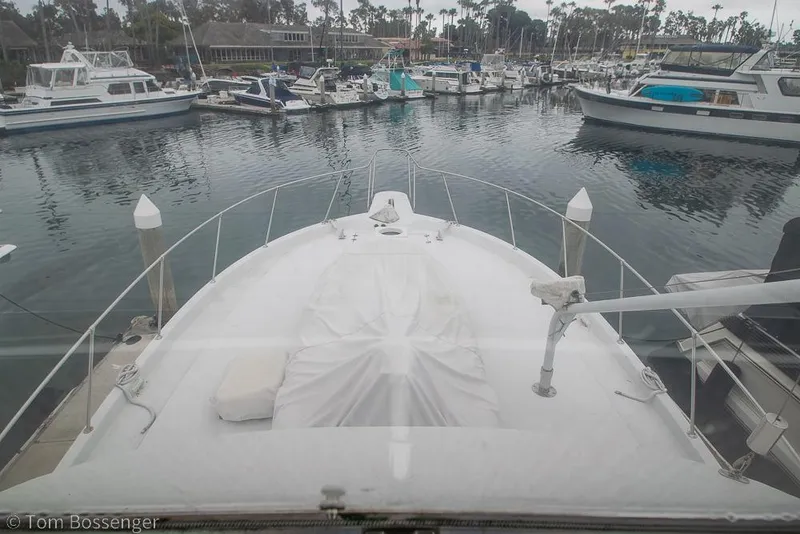 Slide: The Image of 1988 Chris-Craft 482 Convertible yacht docked in a marina, surrounded by other boats. - 35