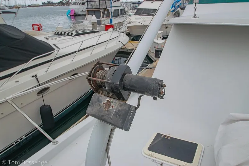 Slide: The Image of 1988 Chris-Craft 482 Convertible boat detail with winch, docked among other vessels. - 37