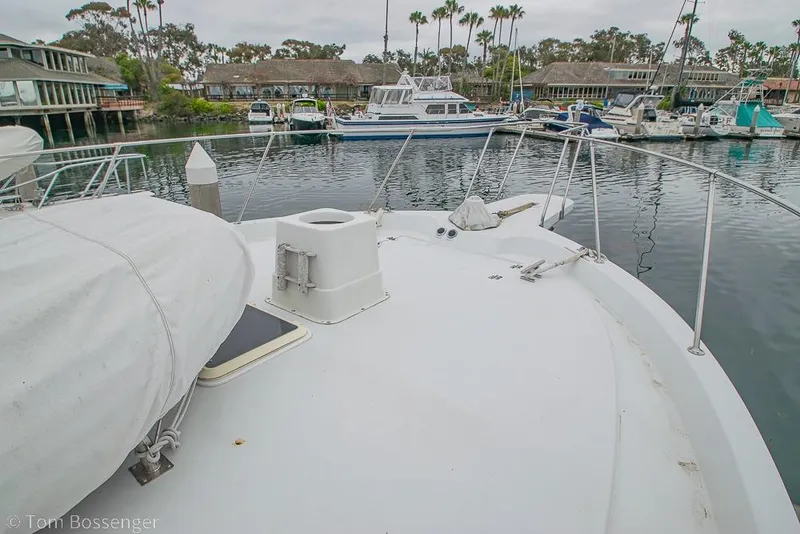 Slide: The Image of 1988 Chris-Craft 482 Convertible yacht docked in a marina with surrounding boats. - 38