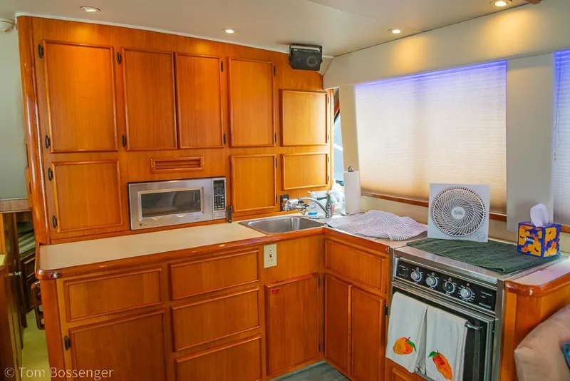 Slide: The Image of Interior of 1988 Chris-Craft 482 Convertible yacht kitchen with wooden cabinets and appliances. - 9