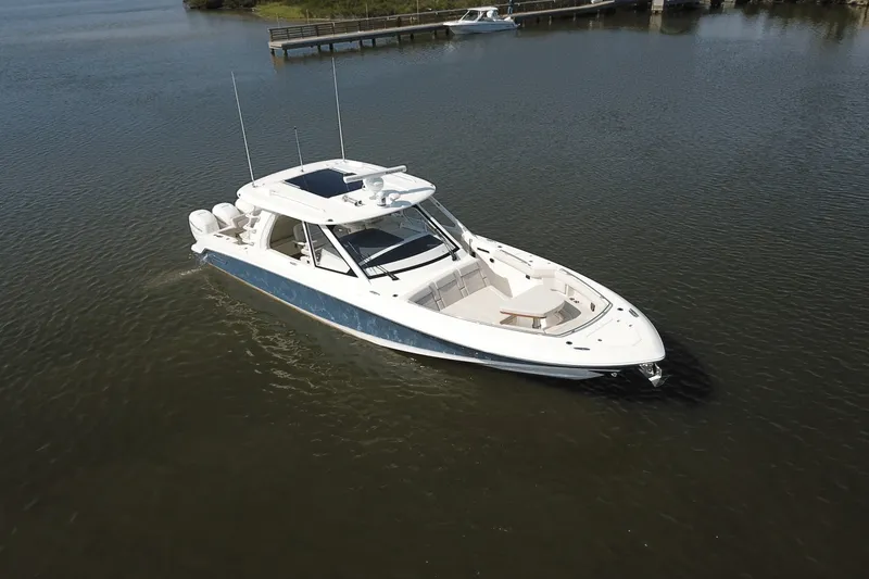 Slide: The Image of 2027 Boston Whaler 380 Realm on calm water, featuring sleek design and spacious deck. - 31