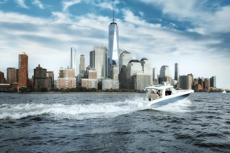 Slide: The Image of Boston Whaler 380 Realm from 2027 cruising on water with a city skyline in the background. - 39