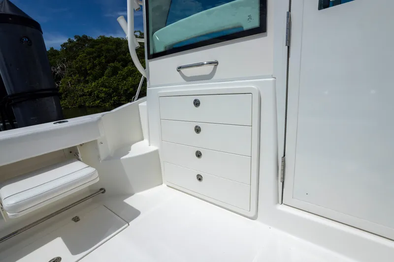 Slide: The Image of 2014 Boston Whaler 315 Conquest boat interior with storage drawers and seating. - 10
